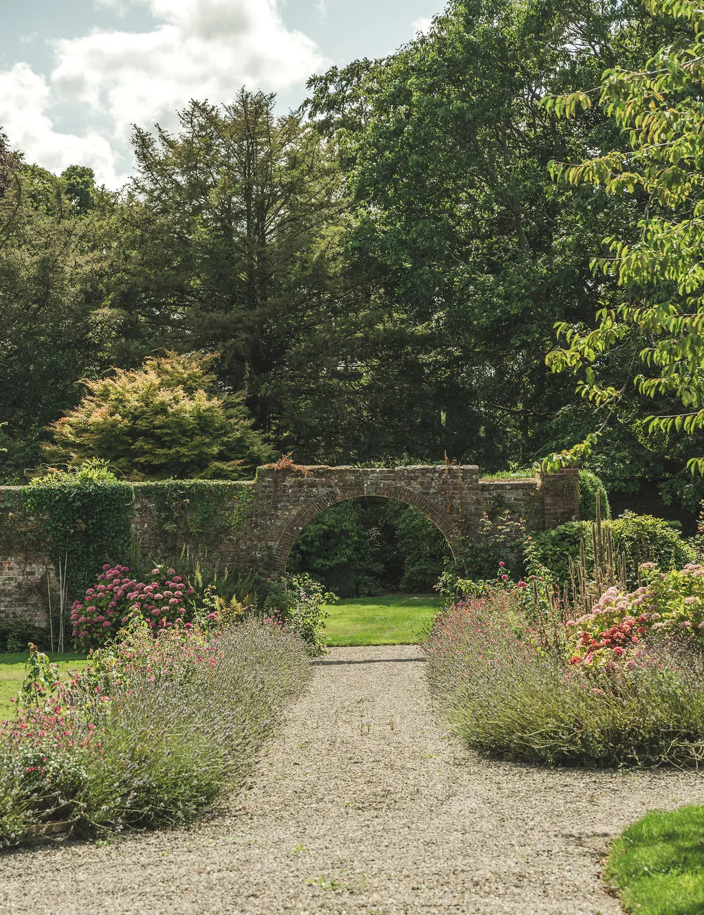 A stone arch in the walled garden framed by flowers
