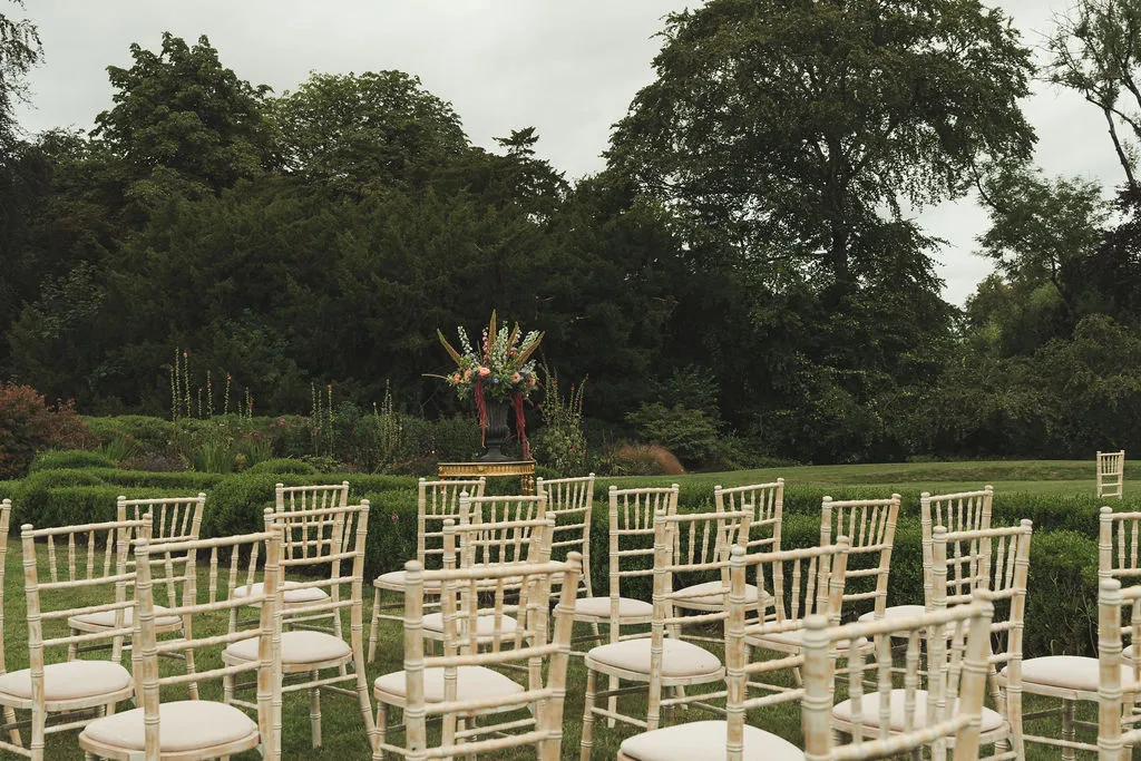 Ceremony chairs arranged in the walled garden, the parkland beyond