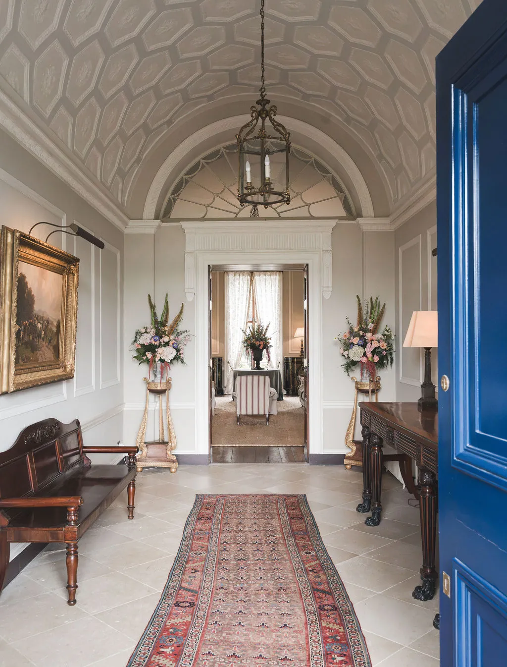 The entrance hall through the open blue front door